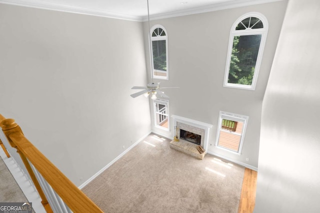 85 Arabian Ave, Alpharetta, GA 30004 - unfurnished living room featuring baseboards, ceiling fan, a brick fireplace, crown molding, and carpet flooring