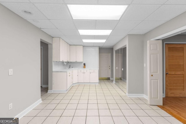 85 Arabian Ave, Alpharetta, GA 30004 - kitchen featuring light countertops, white cabinets, a drop ceiling, baseboards, and a sink