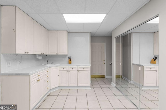 85 Arabian Ave, Alpharetta, GA 30004 - kitchen with a sink, light countertops, a paneled ceiling, light tile patterned floors, and tasteful backsplash