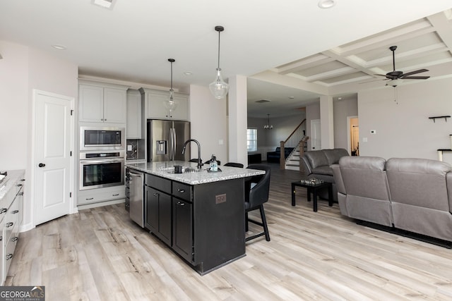 646 Mccarley Downs Dr, Bonaire, GA 31005 - kitchen with appliances with stainless steel finishes, open floor plan, a sink, a kitchen breakfast bar, and a ceiling fan