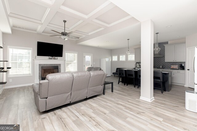 646 Mccarley Downs Dr, Bonaire, GA 31005 - living area with a ceiling fan, light wood finished floors, coffered ceiling, a tile fireplace, and beam ceiling