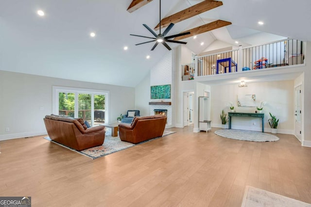 1685 Valley Rd NE, Gainesville, GA 30501 - living area with high vaulted ceiling, ceiling fan, beamed ceiling, a fireplace, and wood finished floors