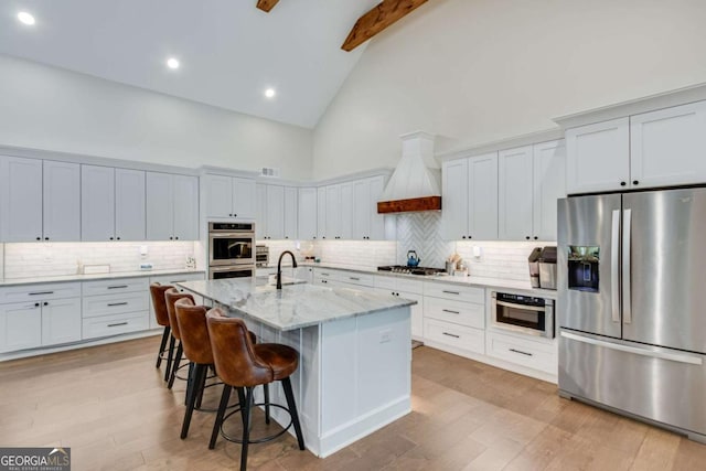 1685 Valley Rd NE, Gainesville, GA 30501 - kitchen with stainless steel appliances, high vaulted ceiling, light wood finished floors, a kitchen breakfast bar, and light stone counters