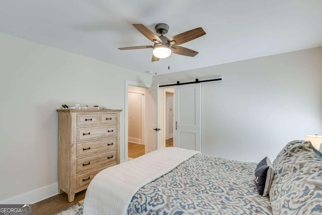 1685 Valley Rd NE, Gainesville, GA 30501 - bedroom featuring a barn door, wood finished floors, and a ceiling fan