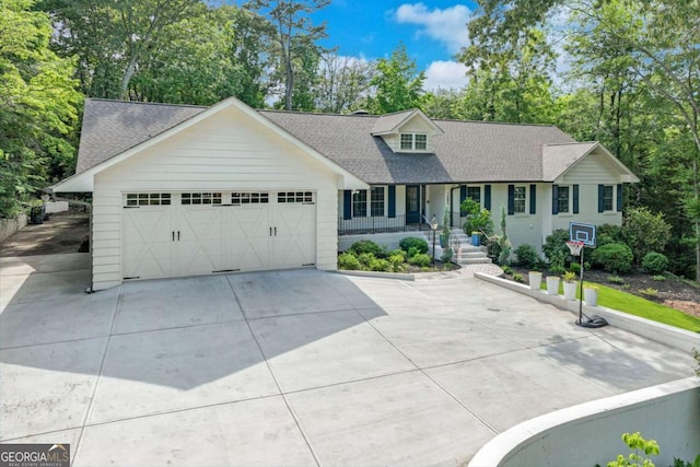 1685 Valley Rd NE, Gainesville, GA 30501 - view of front of house with a shingled roof, a porch, concrete driveway, an attached garage, and view of wooded area