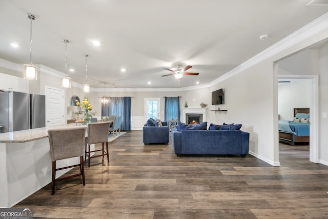 1431 Beckett Dr, Hampton, GA 30228 - living area featuring ceiling fan, ornamental molding, recessed lighting, dark wood-style floors, and a lit fireplace