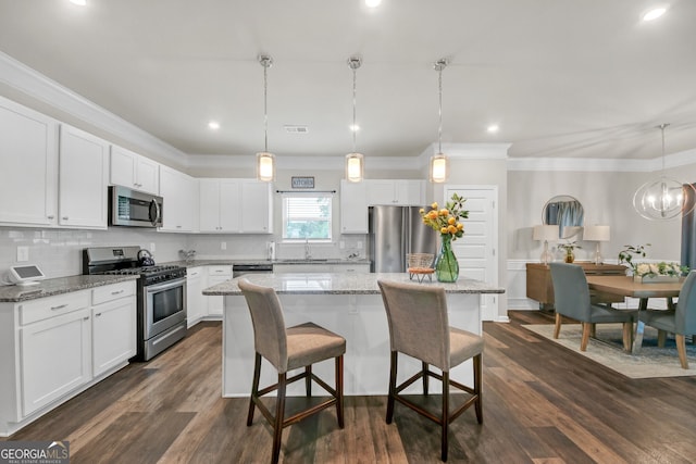 1431 Beckett Dr, Hampton, GA 30228 - kitchen with stainless steel appliances, a sink, a center island, white cabinets, and crown molding