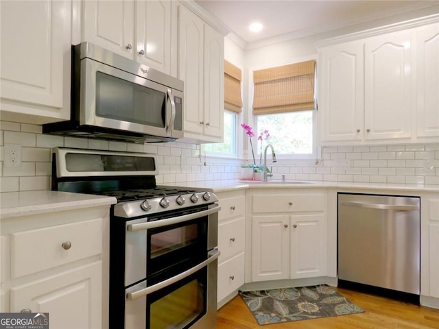 21 Devin Ln, Euharlee, GA 30145 - kitchen with stainless steel appliances, white cabinetry, light countertops, and backsplash