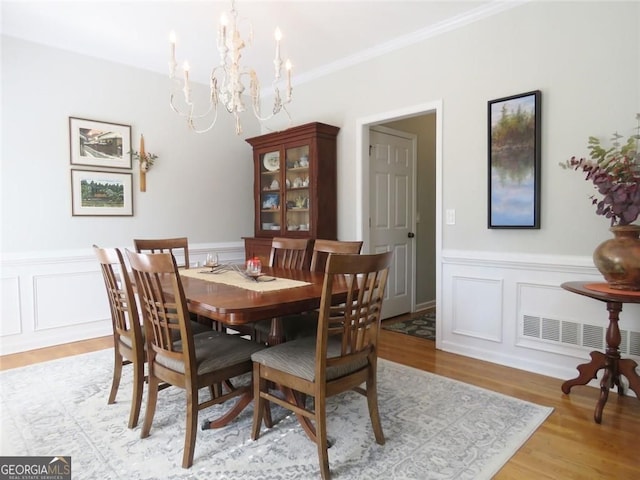 21 Devin Ln, Euharlee, GA 30145 - dining space featuring a chandelier, light wood-type flooring, wainscoting, a decorative wall, and crown molding