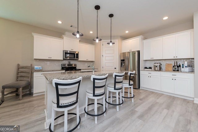 406 Clifton Rd, Perry, GA 31069 - kitchen with appliances with stainless steel finishes, tasteful backsplash, white cabinetry, recessed lighting, and a kitchen bar
