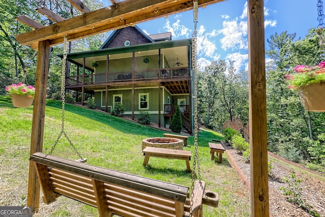 421 Hickory Nut Mountain Rd, Tallulah Falls, GA 30573 - rear view of house featuring a lawn, an outdoor fire pit, a wooden deck, and ceiling fan