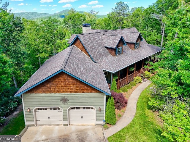421 Hickory Nut Mountain Rd, Tallulah Falls, GA 30573 - view of front facade with a shingled roof, driveway, a chimney, a mountain view, and a front lawn