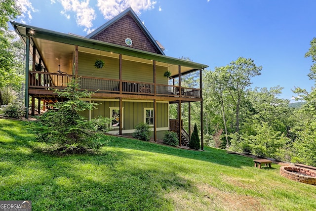 421 Hickory Nut Mountain Rd, Tallulah Falls, GA 30573 - back of property featuring a fire pit, a wooden deck, a yard, stairway, and board and batten siding