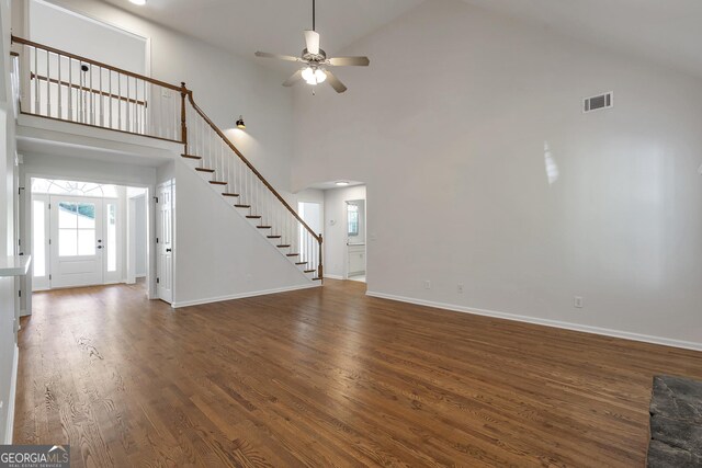 5523 River Valley Way, Flowery Branch, GA 30542 - unfurnished living room featuring high vaulted ceiling, stairway, a ceiling fan, wood finished floors, and baseboards