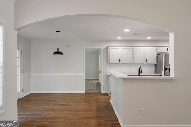 5523 River Valley Way, Flowery Branch, GA 30542 - kitchen with stainless steel fridge, dark wood finished floors, arched walkways, decorative backsplash, and recessed lighting