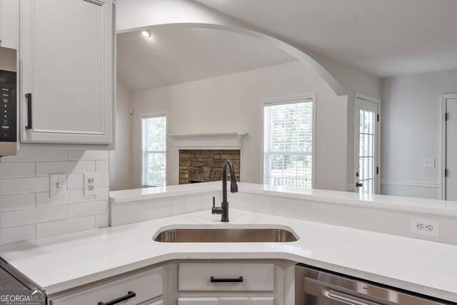 5523 River Valley Way, Flowery Branch, GA 30542 - kitchen featuring stainless steel appliances, a sink, light countertops, tasteful backsplash, and arched walkways