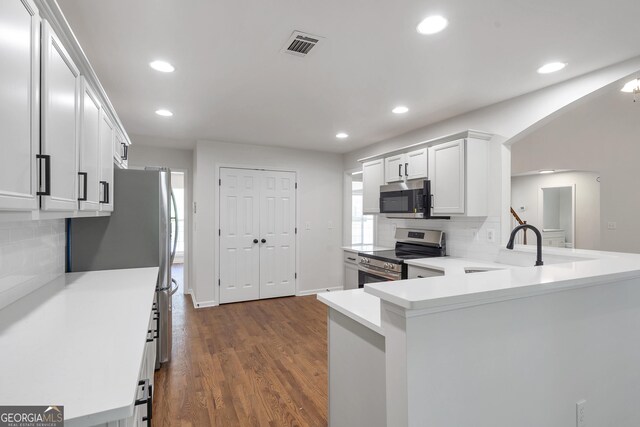 5523 River Valley Way, Flowery Branch, GA 30542 - kitchen with appliances with stainless steel finishes, recessed lighting, decorative backsplash, dark wood-style flooring, and white cabinets