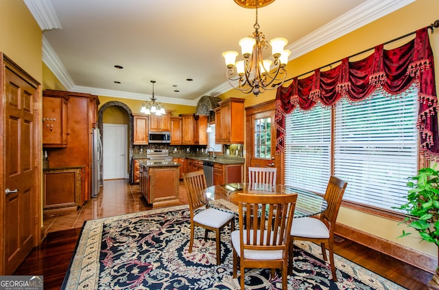 2120 Shaffer Rd, Cumming, GA 30041 - dining room featuring a chandelier, dark wood-style flooring, crown molding, arched walkways, and baseboards