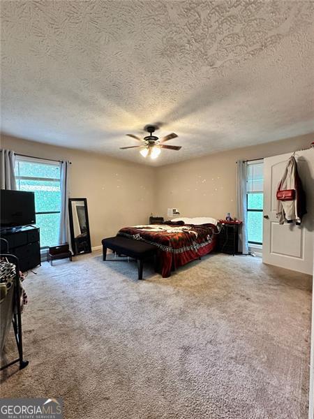 2816 Quinbery Dr, Snellville, GA 30039 - carpeted bedroom featuring a textured ceiling and ceiling fan