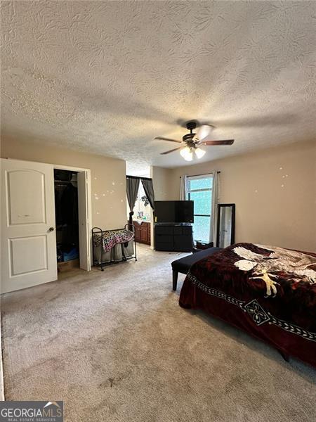 2816 Quinbery Dr, Snellville, GA 30039 - bedroom featuring carpet floors, a textured ceiling, ceiling fan, and a closet
