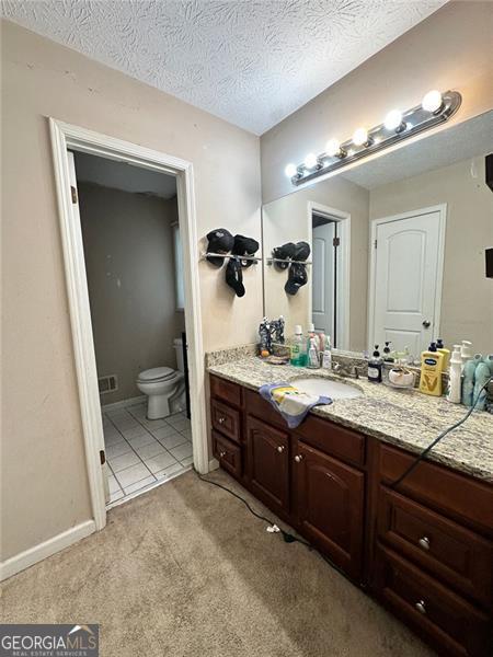 2816 Quinbery Dr, Snellville, GA 30039 - bathroom featuring vanity, toilet, and a textured ceiling