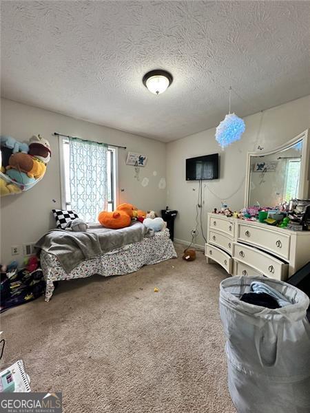 2816 Quinbery Dr, Snellville, GA 30039 - carpeted bedroom featuring multiple windows and a textured ceiling