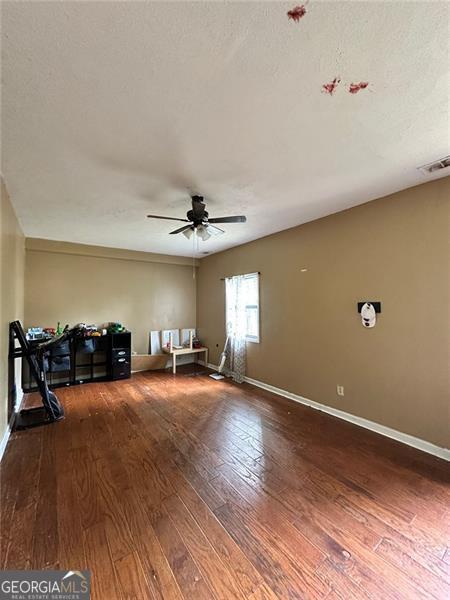 2816 Quinbery Dr, Snellville, GA 30039 - unfurnished living room with hardwood / wood-style floors, ceiling fan, and baseboards