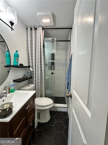 2816 Quinbery Dr, Snellville, GA 30039 - full bath featuring a stall shower, vanity, tile patterned floors, and toilet