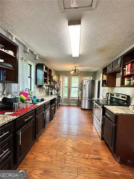 2816 Quinbery Dr, Snellville, GA 30039 - kitchen with open shelves, stainless steel appliances, track lighting, a textured ceiling, and light wood finished floors
