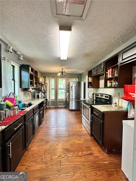 2816 Quinbery Dr, Snellville, GA 30039 - kitchen featuring appliances with stainless steel finishes, open shelves, a textured ceiling, and light wood finished floors