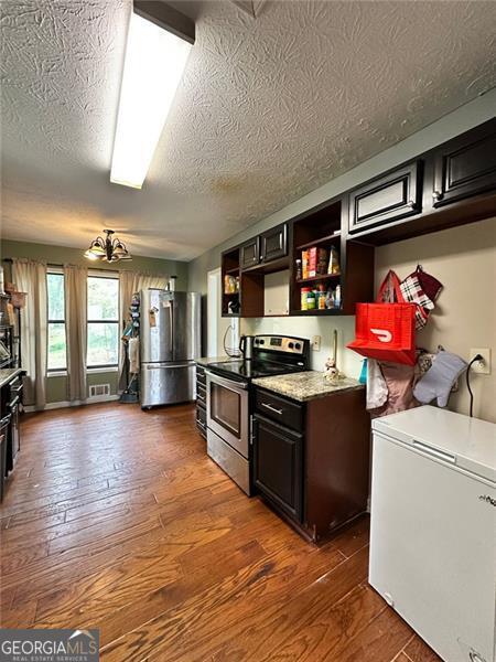 2816 Quinbery Dr, Snellville, GA 30039 - kitchen featuring stainless steel appliances, hardwood / wood-style floors, open shelves, and a textured ceiling