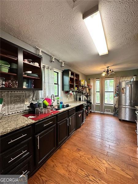 2816 Quinbery Dr, Snellville, GA 30039 - kitchen with freestanding refrigerator, open shelves, a textured ceiling, light wood-style flooring, and rail lighting