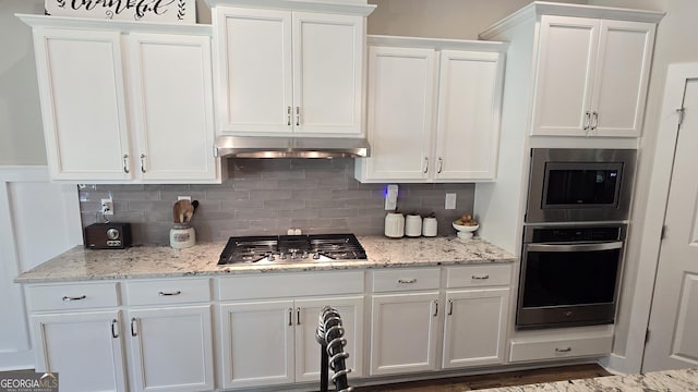 2321 Margaux Ct, Monroe, GA 30656 - kitchen with stainless steel appliances, white cabinets, tasteful backsplash, and light stone counters