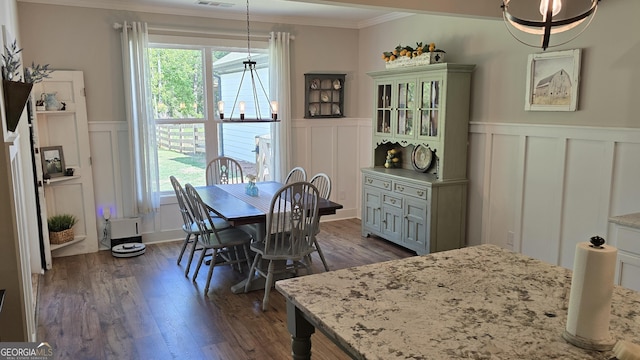 2321 Margaux Ct, Monroe, GA 30656 - dining space featuring a decorative wall, ornamental molding, dark wood-style floors, and wainscoting