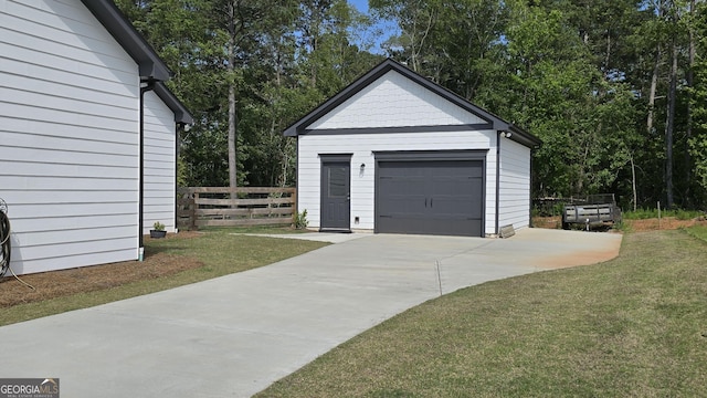 2321 Margaux Ct, Monroe, GA 30656 - detached garage featuring concrete driveway and view of scattered trees