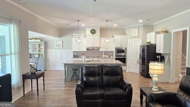 2321 Margaux Ct, Monroe, GA 30656 - kitchen with appliances with stainless steel finishes, white cabinets, dark wood-style floors, crown molding, and pendant lighting