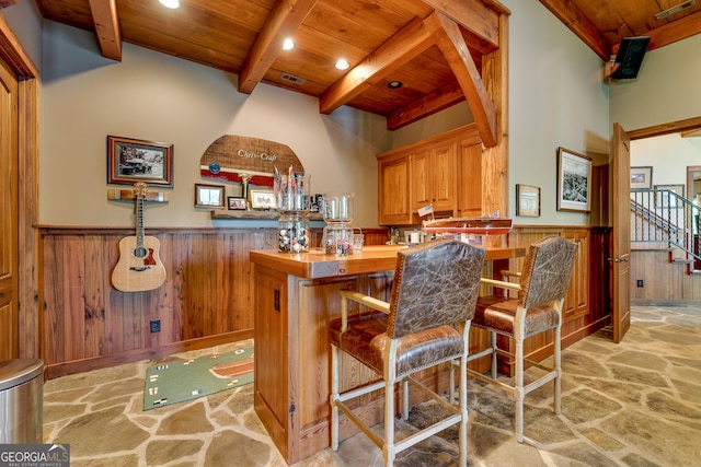 4334 Murray Cove Rd, Tiger, GA 30576 - indoor dry bar with wooden ceiling with exposed beams, stone flooring, wainscoting, wooden walls, and stairway