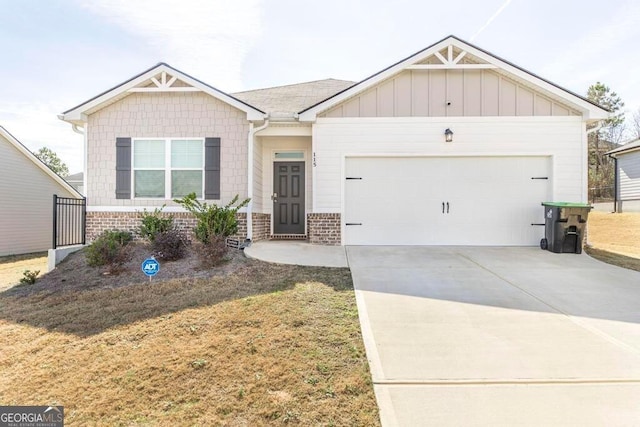 115 Taylor Woods Ct, Bonaire, GA 31005 - view of front of house featuring a garage, driveway, brick siding, and board and batten siding