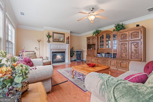 3476 Bridge Walk Dr, Lawrenceville, GA 30044 - living area with crown molding, ceiling fan, a glass covered fireplace, and wood finished floors