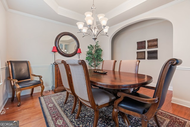 3476 Bridge Walk Dr, Lawrenceville, GA 30044 - dining space with arched walkways, a chandelier, light wood-type flooring, a tray ceiling, and ornamental molding