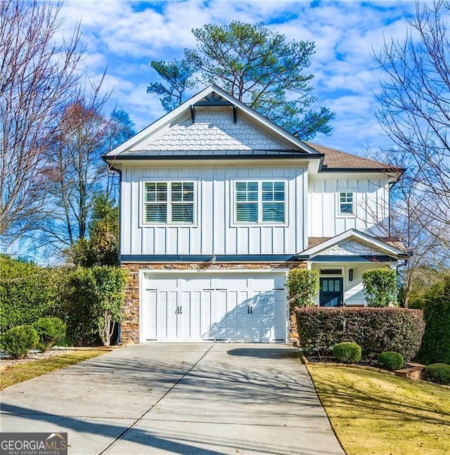 2603 Apple Valley Rd NE, Atlanta, GA 30319 - view of front of house with board and batten siding, an attached garage, concrete driveway, and stone siding