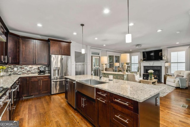 2603 Apple Valley Rd NE, Atlanta, GA 30319 - kitchen featuring appliances with stainless steel finishes, crown molding, plenty of natural light, light stone countertops, and a fireplace