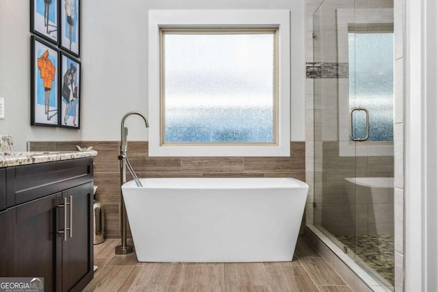 2603 Apple Valley Rd NE, Atlanta, GA 30319 - full bathroom with tile walls, vanity, a soaking tub, a stall shower, and wainscoting