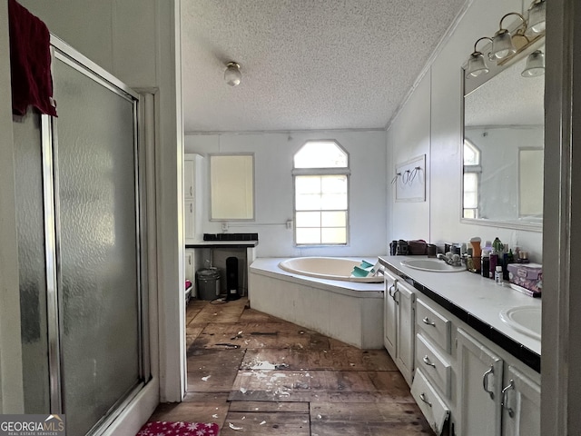 542 Southern Pines Rd, Dublin, GA 31021 - full bath featuring a textured ceiling, a stall shower, a garden tub, double vanity, and hardwood / wood-style floors