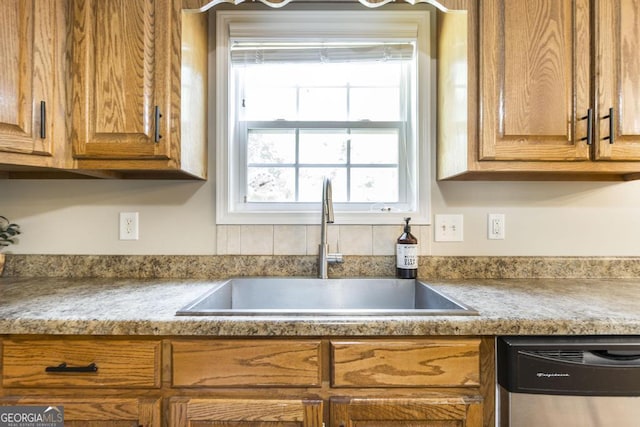 4407 Jones Rd, Macon, GA 31216 - kitchen featuring dishwasher, a sink, brown cabinetry, and light countertops