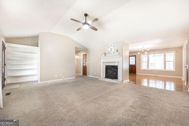 4407 Jones Rd, Macon, GA 31216 - unfurnished living room featuring carpet, ceiling fan, baseboards, a fireplace with raised hearth, and a chandelier