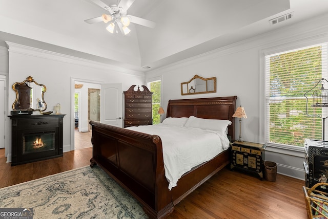 5176 Glen Forrest Dr, Flowery Branch, GA 30542 - bedroom featuring wood finished floors, baseboards, ceiling fan, crown molding, and a glass covered fireplace