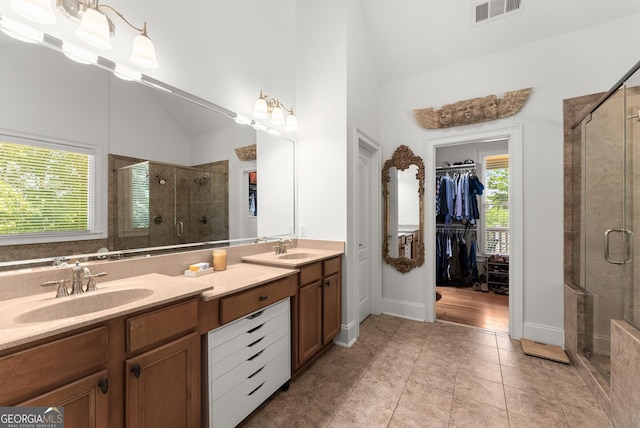 5176 Glen Forrest Dr, Flowery Branch, GA 30542 - bathroom with a stall shower, double vanity, a walk in closet, tile patterned flooring, and lofted ceiling
