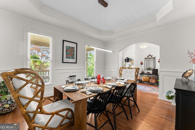 5176 Glen Forrest Dr, Flowery Branch, GA 30542 - dining area with a tray ceiling, crown molding, arched walkways, a decorative wall, and light wood-style flooring