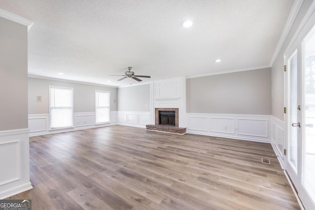 757 Silver Springs Dr, Macon, GA 31210 - unfurnished living room featuring crown molding, ceiling fan, a wainscoted wall, a decorative wall, and a fireplace